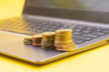 Bilgisayar klavyesinde büyüyen diyagramı hatırlatan bozuk para yığınları. İş büyümesi kavramı, borsa çevrimiçi ticaret kavramı.