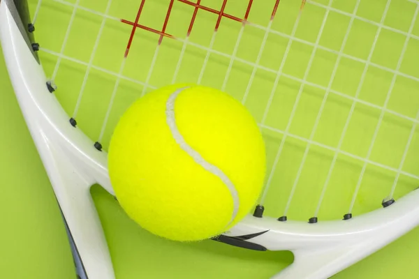 Yeşil arka planda raketi olan bir tenis topu. Spor konsepti.