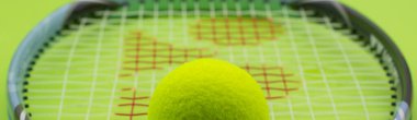 Yeşil arka planda raketi olan bir tenis topu. Spor konsepti.
