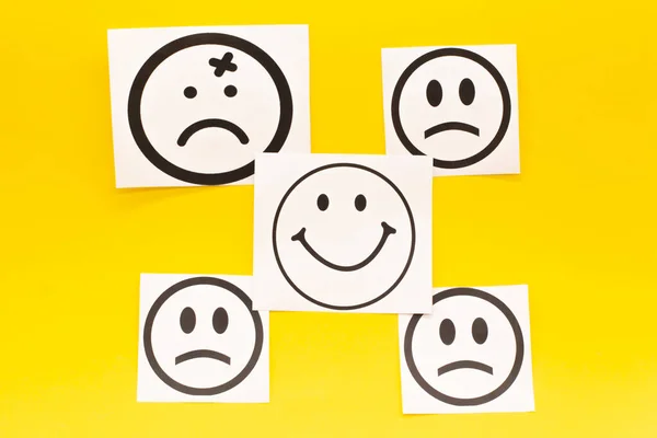 smiling face and sad face on yellow background. Positive thinking concept.