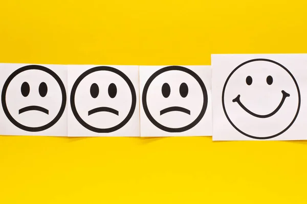 smiling face and sad face on yellow background. Positive thinking concept.