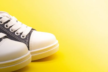 Sarı arka planda beyaz ayakkabılar..