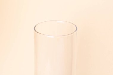 Bej arkaplanda cam şeffaf vazo