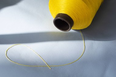 Mavi derili sarı iplik makarası. Dikiş ipliği