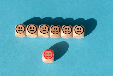 Mutlu ve mutsuz yüzlü tahta blok. Müşteri hizmetleri derecelendirmesi veya memnuniyet kavramı. İş hizmeti derecesi, müşteri memnuniyeti