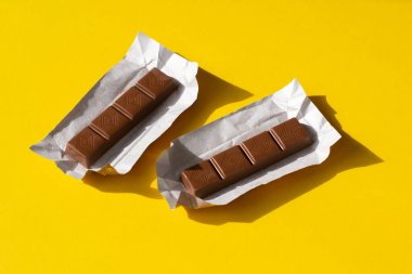 Sarı arka planda küçük çikolatalar.