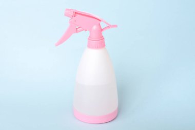 Mavi arka planda ev için renkli plastik sprey şişesi