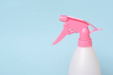 Mavi arka planda ev için renkli plastik sprey şişesi