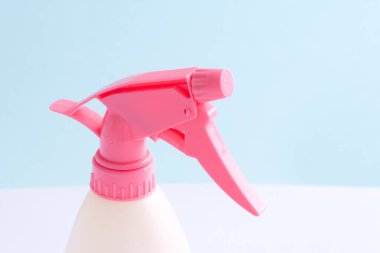 Mavi arka planda ev için renkli plastik sprey şişesi