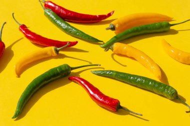 Sarı arka planda renkli kırmızı biber.