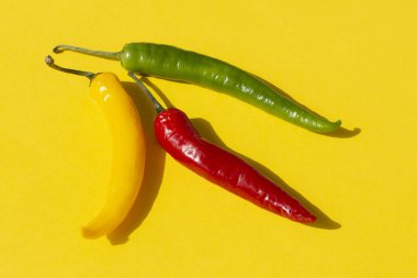 Sarı arka planda renkli kırmızı biber.