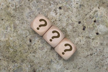 Çimento arkaplanındaki tahta küplerde bir soru işareti. Sorular, Cevaplar ve Beyin Fırtınası Konseptleri