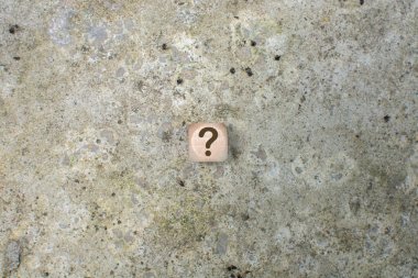 Çimento arkaplanındaki tahta küplerde bir soru işareti. Sorular, Cevaplar ve Beyin Fırtınası Konseptleri