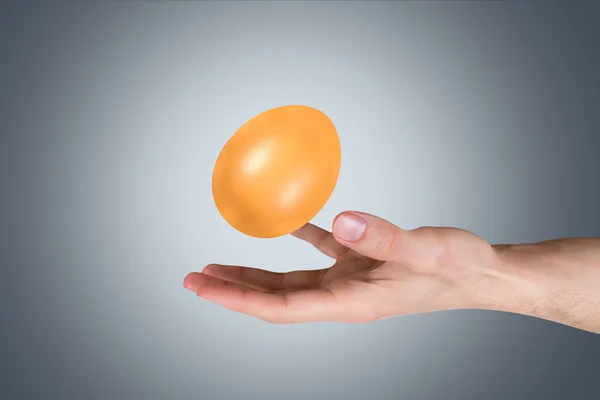 Рука держит золотое яйцо — стоковое фото