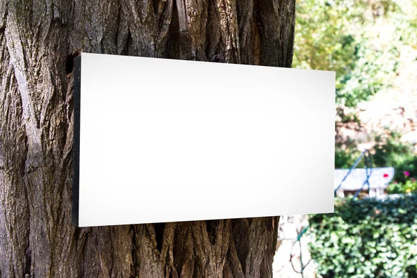 Tablero de signos en blanco en el cuerpo del árbol — Foto de Stock