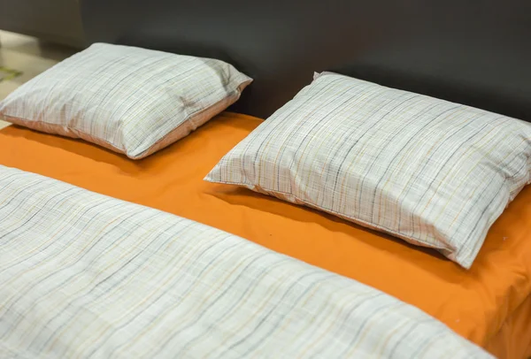 Цвет чистые одеяла и подушки на кровати и диване — стоковое фото