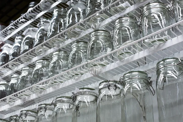 Transparant glas gerechten en kruiken op planken — Stockfoto