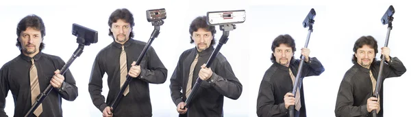 Siyah gömlekli bir adam bir elektrik süpürgesi tutuyor