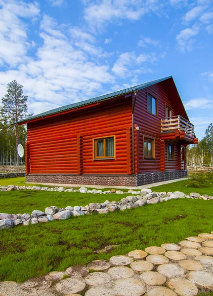 Casa in legno rosso nel villaggio Foto Stock Royalty Free