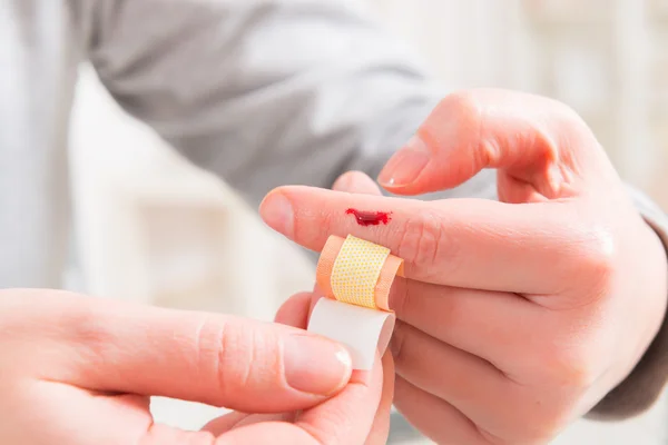 Använda självhäftande bandage på finger — Stockfoto