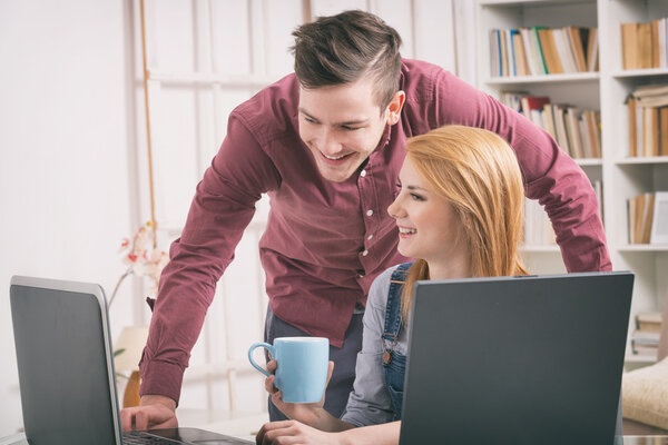 Happy couple at home with laptop computer