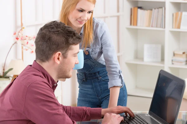 Casal feliz em casa com computador portátil — Fotografia de Stock