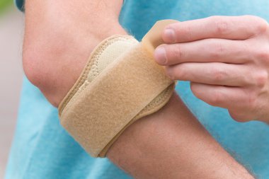 Dirsek küme ayracı giyen adam