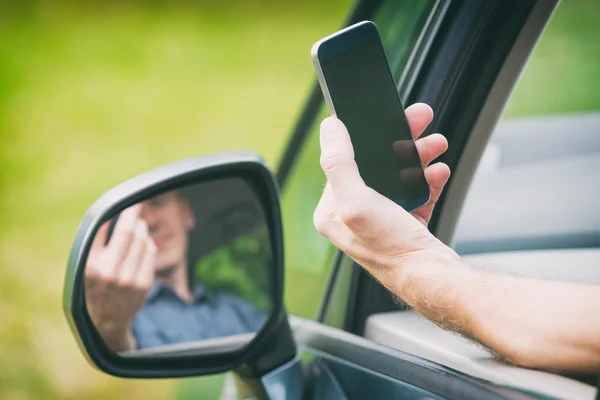 Человек со смартфоном в машине — стоковое фото
