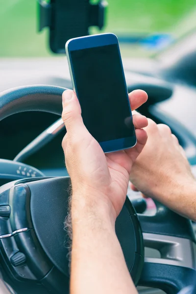 Man met slimme telefoon in de auto — Stockfoto