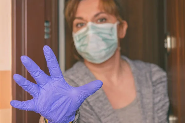 由于科罗那病毒Covid 19的流行 一名戴着防护面罩的妇女打开了她家的大门 家庭检疫和自我隔离概念 — 图库照片
