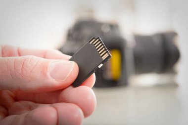 El kamerası hafıza kartı, arka planda DSLR.