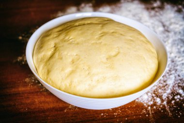 Beyaz ekmek, ekmek ve pizza için hamur hazırlıyorum. Buğday unundan yapılmış bir kasedeki maya hamuru..