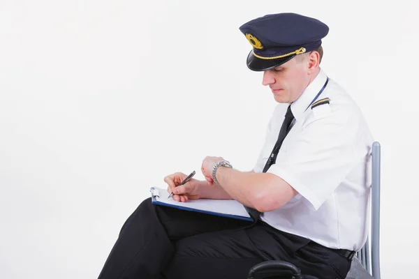 航空会社の機長が飛行機の前に書類を記入し 彼の時計を見て — ストック写真