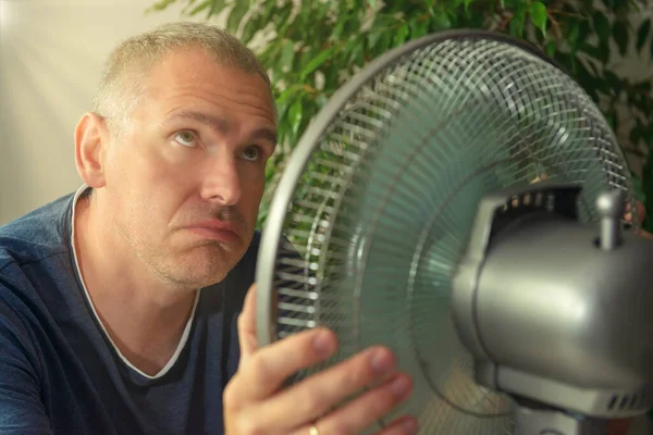Uomo Soffre Calore Mentre Seduto Sala Cerca Rinfrescarsi Dal Ventilatore — Foto Stock