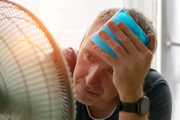 Homem Sofre Calor Dor Cabeça Enquanto Sentado Sala Tenta Refrescar — Fotografia de Stock