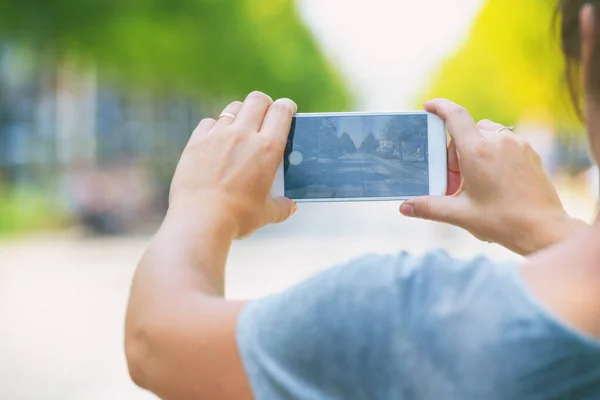 スマホで街中で写真を撮る女 — ストック写真