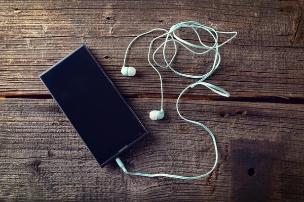 Auriculares pequeños con teléfono móvil —  Fotos de Stock