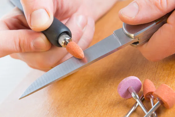 Macinazione di un vecchio coltello con mola rotativa — Foto Stock