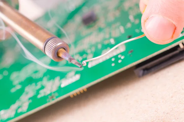 Serviceman soldering on PCB — Stock Photo, Image