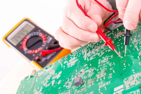 Serviceman checks PCB with a digital multimeter — Stock Photo, Image