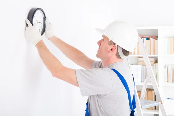 Man hanging clock — Stock Photo, Image