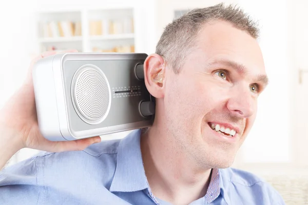 Hombre con discapacidad auditiva tratando de escuchar la radio —  Fotos de Stock