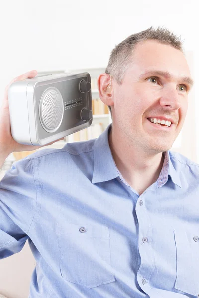 Hearing impaired man trying to listen radio — Stock Photo, Image