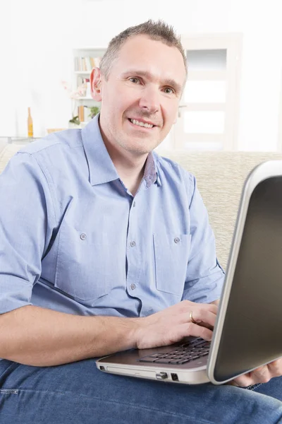 Человек с нарушением слуха, работающий с ноутбуком — стоковое фото