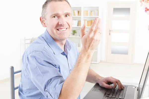 Hearing impaired man working with laptop — Stock Photo, Image