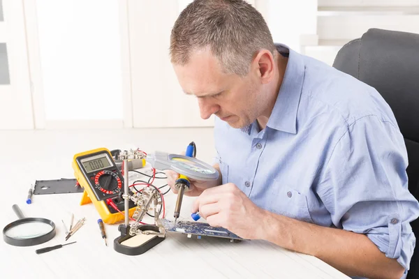 Serviceman soldering on PCB — Stock Photo, Image