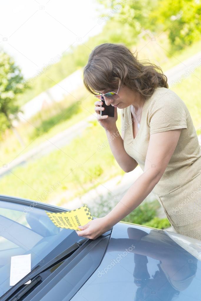 woman looking on parking ticket