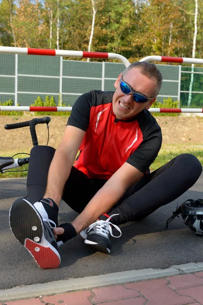 Biker segurando seu tornozelo . — Fotografia de Stock