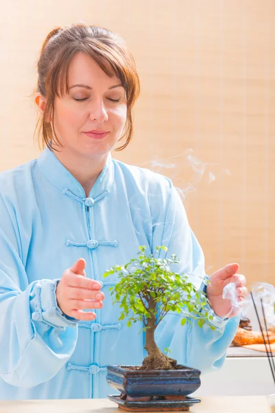 Kvinde med bonsai træ - Stock-foto