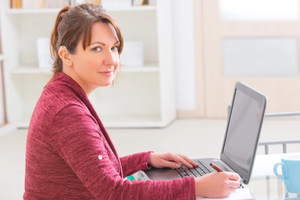 Mulher deficiente auditiva trabalhando com laptop — Fotografia de Stock